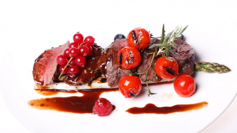 Medallions of pork, meat, asparagus, raspberries, red currant sauce, cherry tomatoes (horizontal)