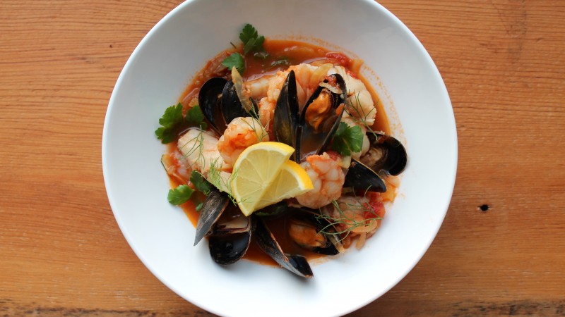 seafood soup, tomatoes, mussels, shrimp, greens (horizontal)