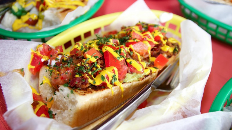 dat dog, hot dog, ketchup, mustard, lettuce, tomatoes, peppers, cucumbers (horizontal)