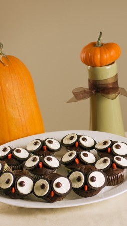 Halloween, All Hallows' Eve, All Saints' Eve, holiday table, candy, muffins, apple, pumpkin (vertical)