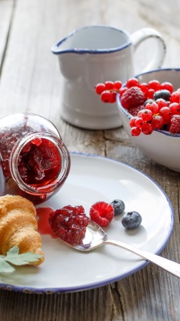 French croissants, jam, berries, raspberries, blueberries, currants, tea (vertical)