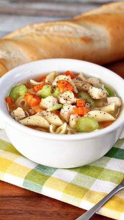 soup, chicken, noodles, carrots, peppers, onion, baguette (vertical)