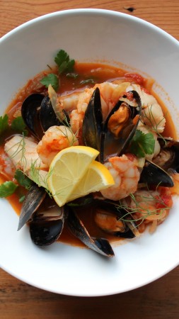 seafood soup, tomatoes, mussels, shrimp, greens (vertical)